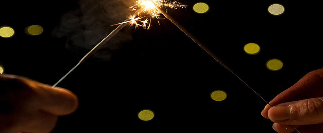 Two,Hands,Holding,Burning,Celebration,Sparklers,And,Creating,A,Festive