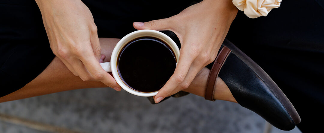 Top-down,View,Of,A,Woman,Sitting,Cross-legged,,Holding,A,White